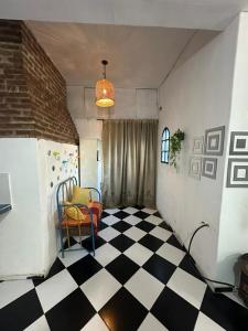 a room with a chair and a checkered floor at Hospedaje San Vicente in San Vicente