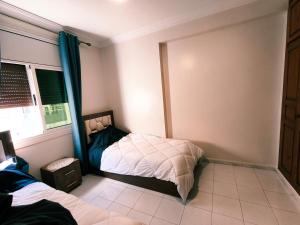 a small bedroom with a bed and a window at Chez Atlas in Kenitra