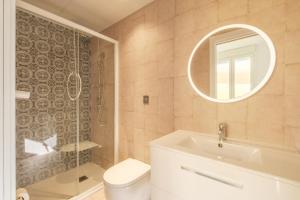 a bathroom with a toilet and a sink and a mirror at Marvellous Apt with a Large Private Terrace in Valencia +26 photos