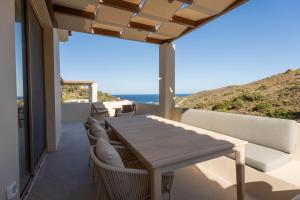 a dining room with a table and chairs and the ocean at Oleander Evia in Agioi Apostoli