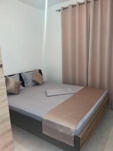 a bed in a room with a curtain at Sun Stay in Bar