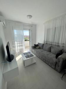 a living room with a couch and a tv at Sun Stay in Bar