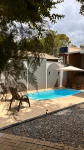 a swimming pool with a chair and an umbrella at Villa Sairé in Alter do Chao