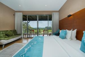 a bedroom with a large bed and a couch at Trio Lodge- Habarana in Habarana