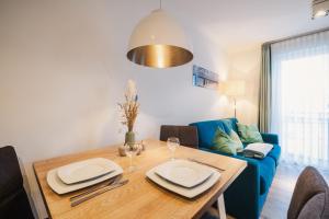 a dining room with a table and a blue couch at Am Park 14 in Prerow