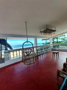 a room with chairs and tables and a hanging basket at Hidden Pearl Beach Villa in Pondicherry