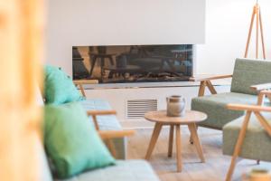 a living room with a couch and a fireplace at Am Park 14 in Prerow