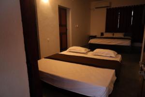 a room with three beds in a room at Hidden Pearl Beach Villa in Pondicherry +15 photos