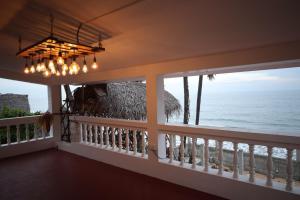 a room with a balcony with a view of the ocean at Hidden Pearl Beach Villa in Pondicherry