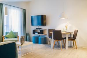 a living room with a table and a tv on the wall at Am Park 24 in Prerow