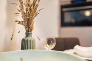 a vase with a plant in it next to a glass at Am Park 13 in Prerow