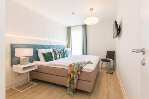 a bedroom with a bed with a blue headboard at Am Park 13 in Prerow