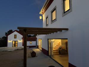 a white house with a wooden archway in front of it at AlcaidariaVista in Ourém +44 photos