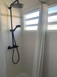a shower with a shower head in a bathroom at Chic, bright and quiet in Baie-Mahault +14 photos