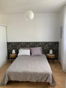 a bedroom with a large bed with two side tables at Chic, bright and quiet in Baie-Mahault