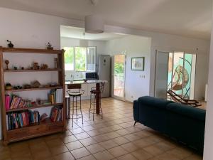 a living room with a blue couch and a kitchen at Chic, bright and quiet in Baie-Mahault