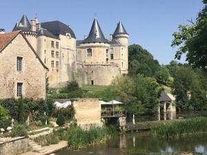 a large castle sitting next to a river at Le Blanc Spa in Nanteuil-en-Vallée