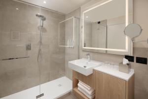 a bathroom with a sink and a shower at Courtyard by Marriott Milano Linate in Milan