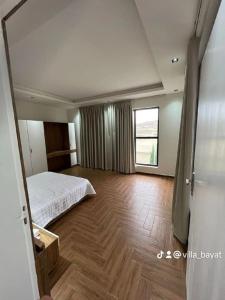 a bedroom with a bed and a wooden floor at شاليهات بيات فيلا نورسين in Abha