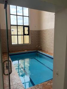 a large swimming pool in a room with a window at شاليهات بيات فيلا نورسين in Abha