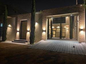 a brick building with a garage at night at شاليهات بيات فيلا نورسين in Abha +3 photos