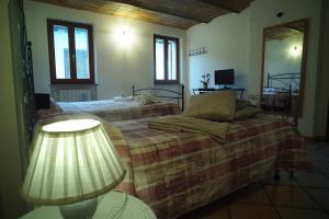 a bedroom with two beds and a lamp at Affittacamere Fulginiae in Foligno