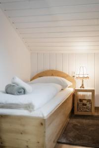 a bedroom with a wooden bed and a lamp at Haus Erlenau in Dalaas
