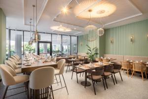 a dining room with tables and chairs and windows at Courtyard by Marriott Milano Linate in Milan +27 photos
