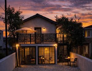a house with an umbrella and a table in front of it at Baykus Deluxe in Kuşadası