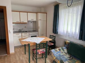 a small kitchen with a table and a couch at Alpakahof Strieder in Maria Luggau