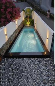 a small swimming pool with a garden on a house at Baykus Deluxe in Kuşadası