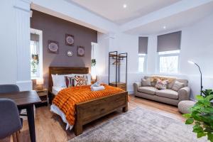 a bedroom with a bed and a desk and a couch at Glan Neigr Apart-Hotel by Guestz in Rhosneigr