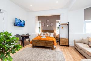 a living room with a bed and a couch at Glan Neigr Apart-Hotel by Guestz in Rhosneigr