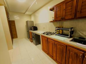 a kitchen with wooden cabinets and a stove top oven at Chez Atlas in Kenitra +6 photos