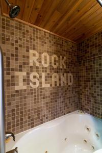 a bathroom with a tub and a tiled wall at The Train Station in Salina +11 photos
