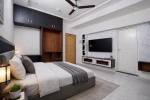 a bedroom with a large bed and a flat screen tv at DJ Imperial Suites in Trivandrum