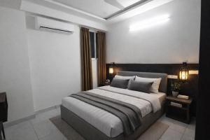 a bedroom with a large bed and two lamps at DJ Imperial Suites in Trivandrum