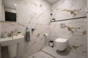 a bathroom with a toilet and a sink at DJ Imperial Suites in Trivandrum