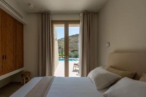 a bedroom with a bed and a sliding glass door at Oleander Evia in Agioi Apostoli +232 photos