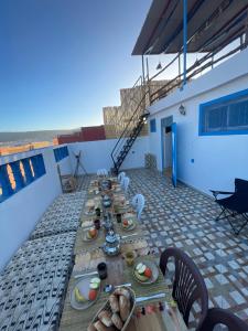 a long table with plates of food on a roof at Tayri Surf House Aourir in Agadir