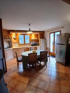 a kitchen with a table and chairs and a refrigerator at Alby in Alby