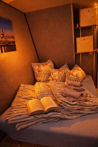 an unmade bed with two books on it at ÖKO Budget Hausboot Retreat Mondschein in Stralsund