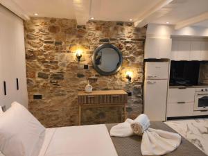 a bedroom with a stone wall and a kitchen at Castle View Serenity in Koroni