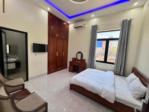 a bedroom with a bed and a tv and a window at Tiến Đạt Villa in Vung Tau
