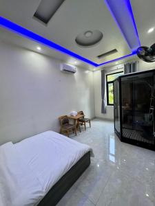 a bedroom with a bed and a tv and a table at Tiến Đạt Villa in Vung Tau