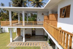 an external view of a house with a wooden deck at Beach House by Unrushed in Welhengoda +29 photos