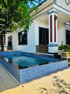 a swimming pool in a house with a blue and white at Tiến Đạt Villa in Vung Tau