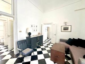 a living room with a couch and a checkered floor at Milonghita Apartment Ortigia by Ortigiaapartments in Syracuse