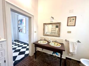 a bathroom with two sinks and a mirror at Milonghita Apartment Ortigia by Ortigiaapartments in Syracuse