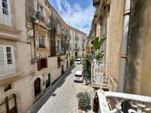 an alley with a car parked on a street at Milonghita Apartment Ortigia by Ortigiaapartments in Syracuse